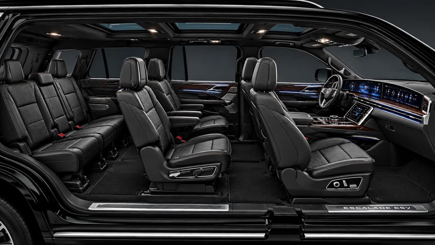 Cadillac Escalade interior with black leather seats and a digital dashboard, seen through an open door.