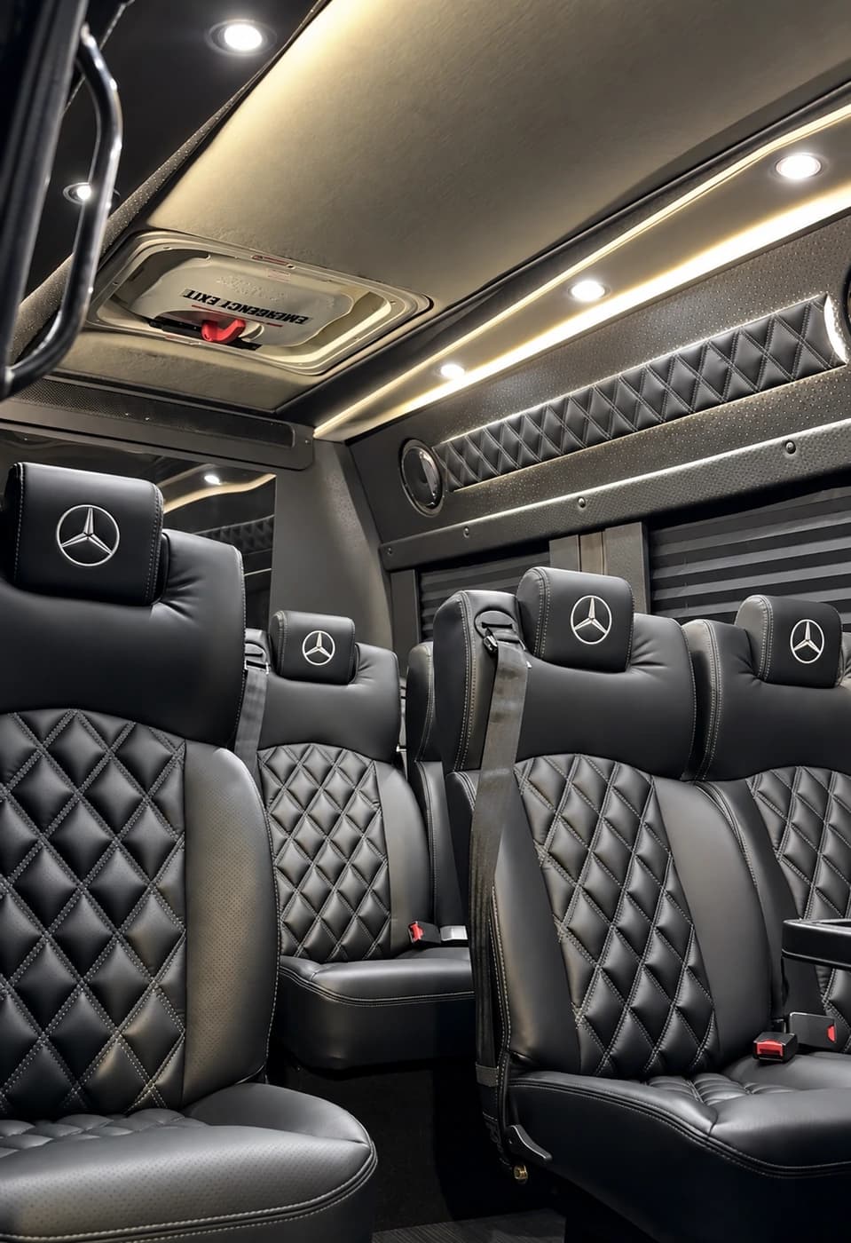 The Mercedes-Benz Executive Sprinter shows black quilted leather seats, ambient ceiling lighting, and a roof emergency hatch.